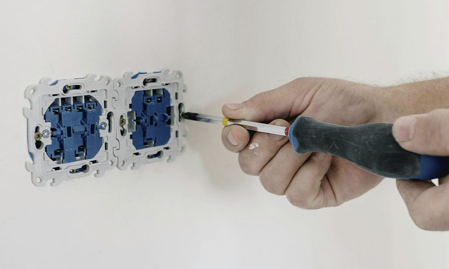 Hombre desatornillando un enchufe de la luz